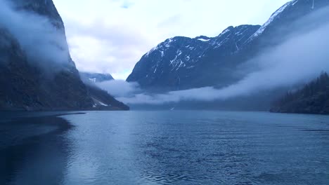 incredible clouds and fog hang over a fjord in norway in timelapse