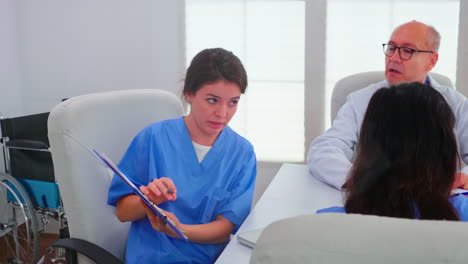 female nurse holding clipboard explaining diagnosis