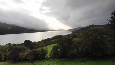 aerial view of over green valley river bank with loch tummel in background