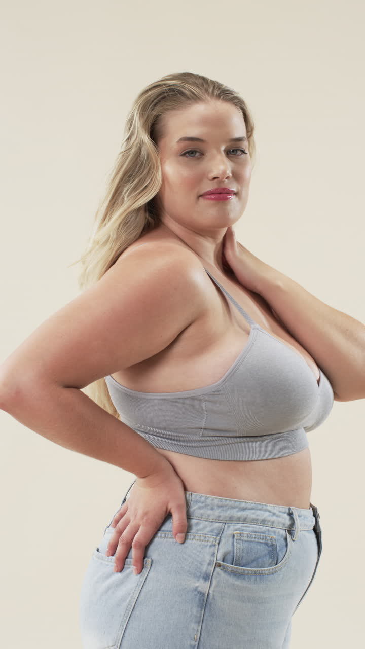 Video verticale: Donna curvy sicura di sé in abbigliamento casual in posa, che abbraccia la body positivity e l'accettazione di sé.
