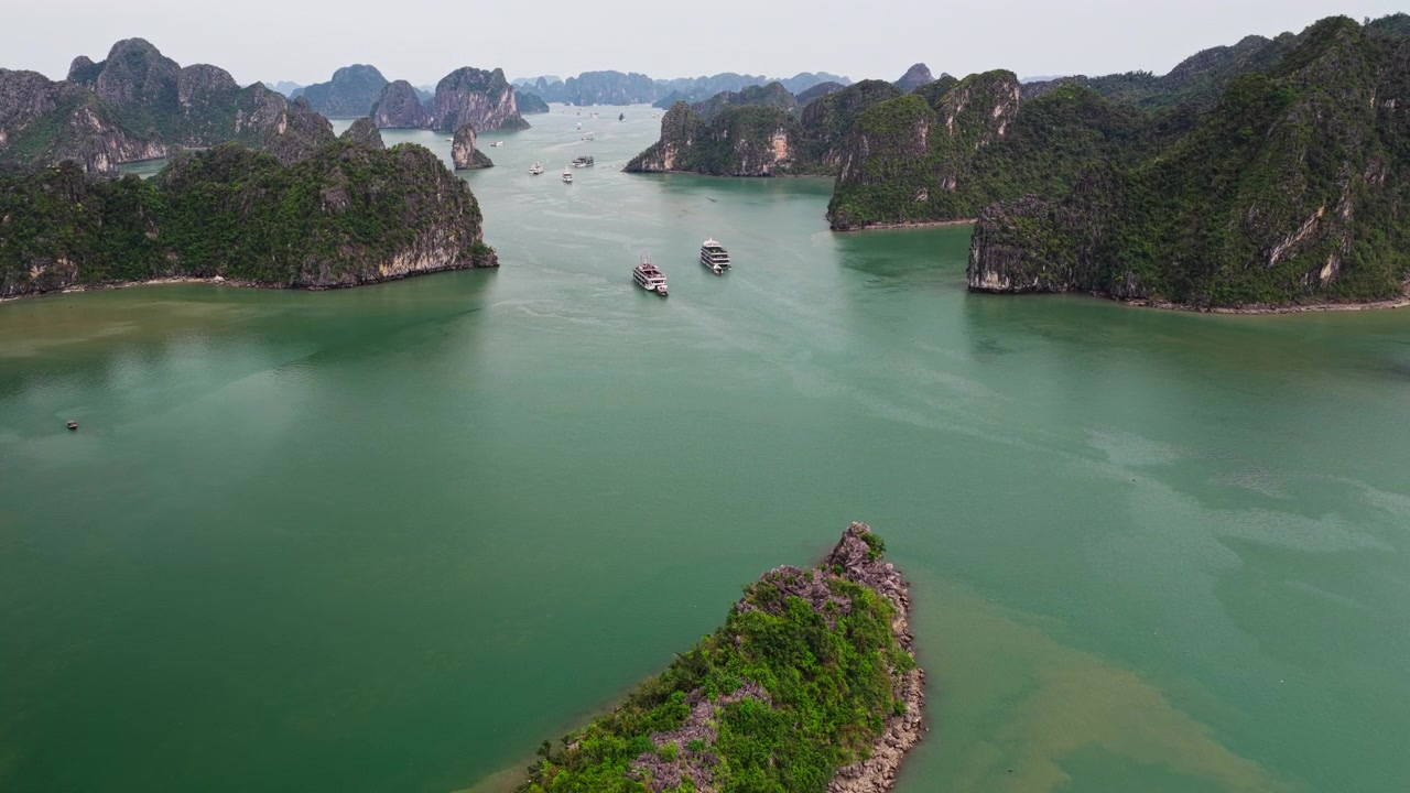 Vịnh Hạ Long Việt Nam: Cảnh quay dolly trên không tiến vào hành trình của những du thuyền sang trọng qua các hòn đảo trên biển ngọc lục bảo nhiệt đới.