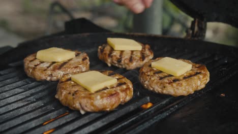 hamburguesas cocinando en una parrilla