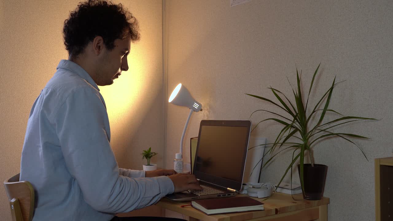 el hombre estornuda y se cubre la boca con la mano experimentando síntomas de covid-19 mientras hace trabajo de oficina en casa - tiro medio