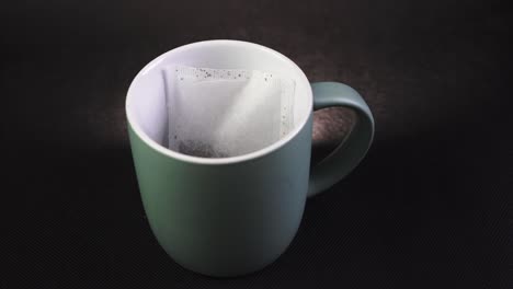 putting a tea bag into a mug