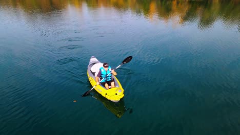 stunning aerial 4k drone footage of a kayaker paddling through a tranquil lake