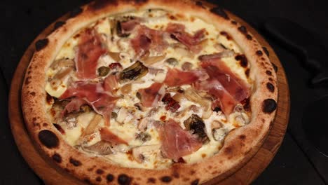 gourmet pizza with prosciutto, mushrooms, and artichoke