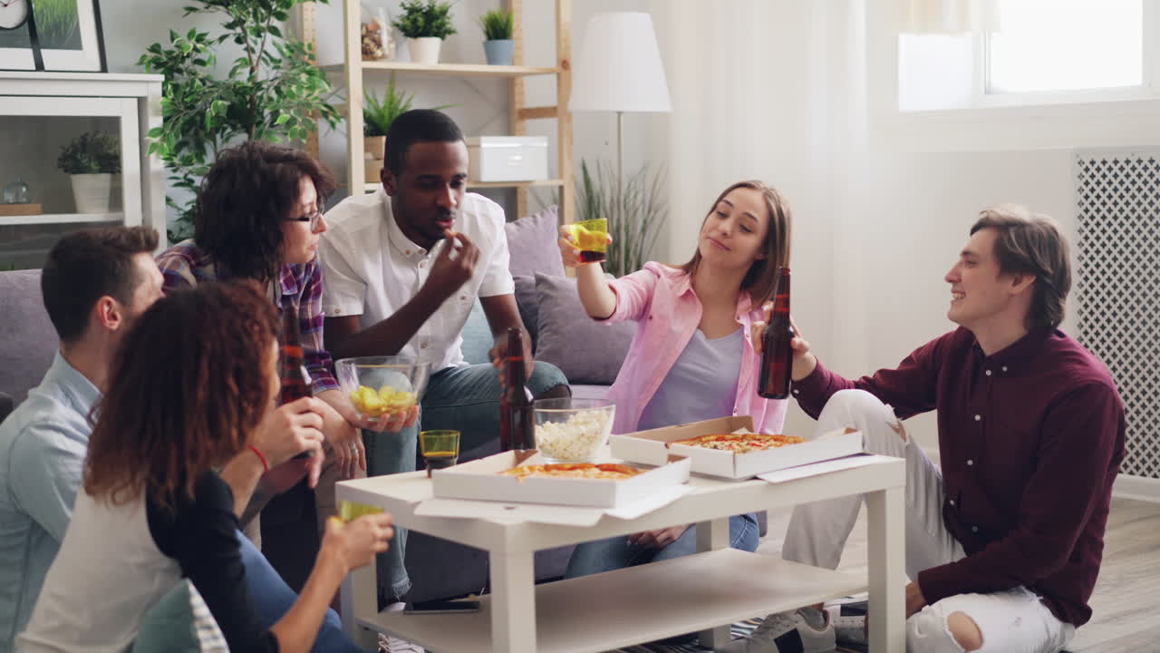 amigos disfrutando de pizza y bebidas en casa