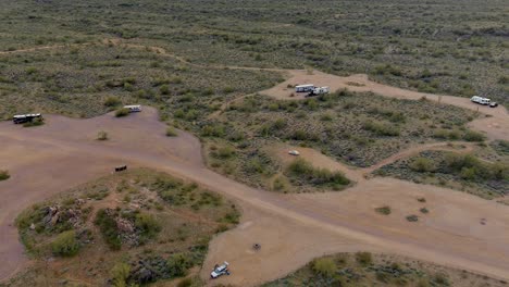 Aerial-pullback-revealing-flat-Arizona-campground-and-horizon-in-the-distance,-dusk