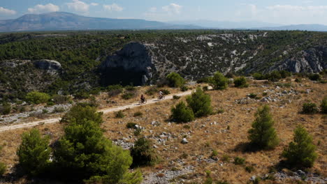 Vista-Aérea-De-Ciclistas-Que-Viajan-Por-Senderos-De-Montaña-Hacia-El-Mirador-Del-Parque-Nacional-Krka-En-Croacia