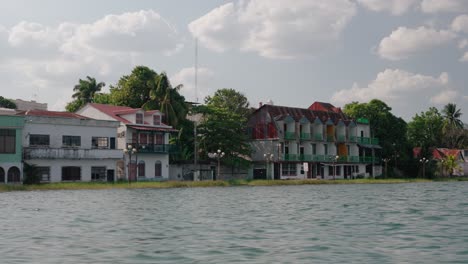 vibrant lakeside buildings in flores, guatemala, viewed from the calm waters of lake petén itzá.
