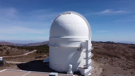 Drone-aerial-view-of-Calar-Alto-Observatory-at-the-snowy-mountain-top-in-Almeria,-Andalusia,-Spain