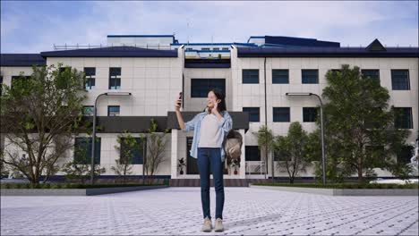 학교 건물 앞에서 셀피를 찍는 십대