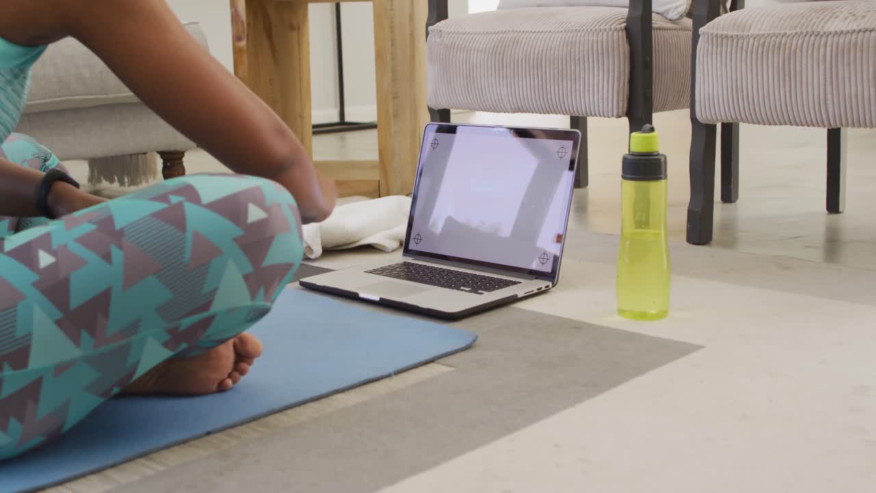 feliz afroamericano usando ropa deportiva, haciendo ejercicio, usando una computadora portátil con espacio para copiar