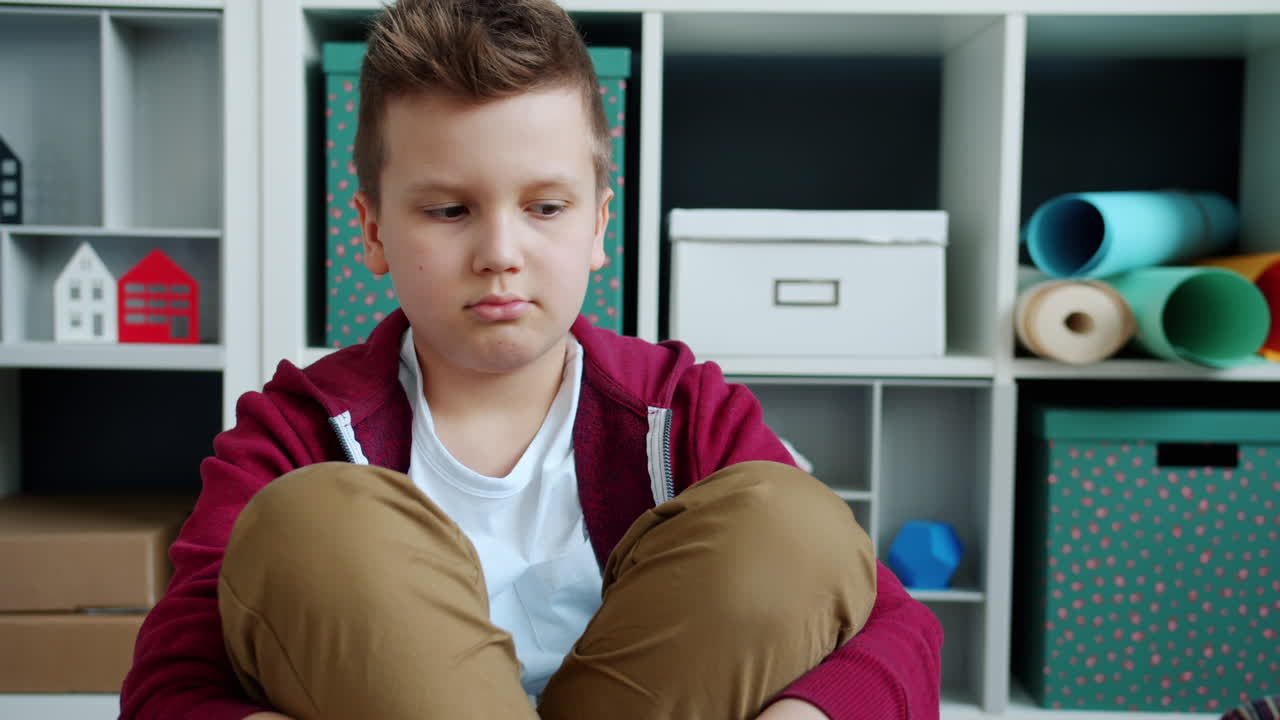 Ragazzo triste seduto per terra