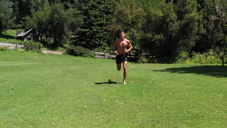 Young-caucasian-fit-attractive-male-exercising-outdoors-with-green-vegetation-background-in-4K