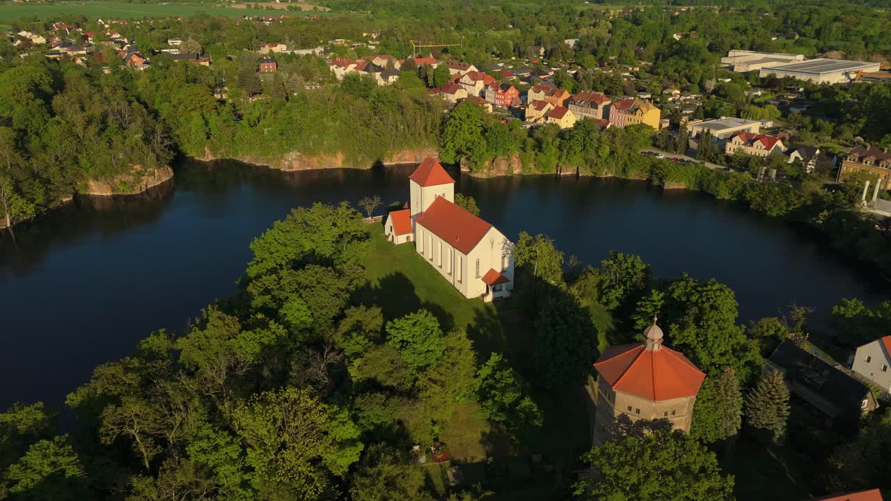 Drone shot of Beucha’s iconic cliffside church with full view of the flooded quarry and nearby town. Captured at golden hour, the landscape combines architecture, water and nature.