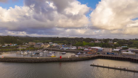 clouds flying by above port of bandon in oregon in an overcast weather - hyper lapse, arc shot