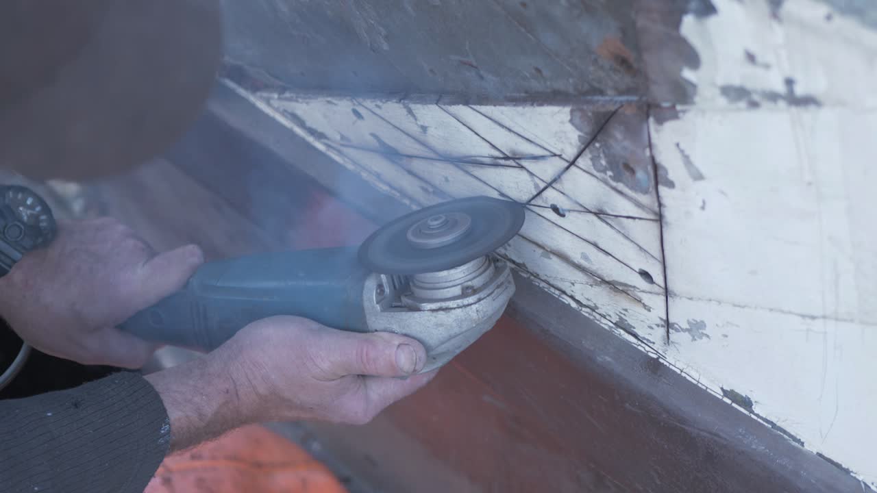 木製ボートのアングルグラインダーで腐ったマホガニーの板を切り出す