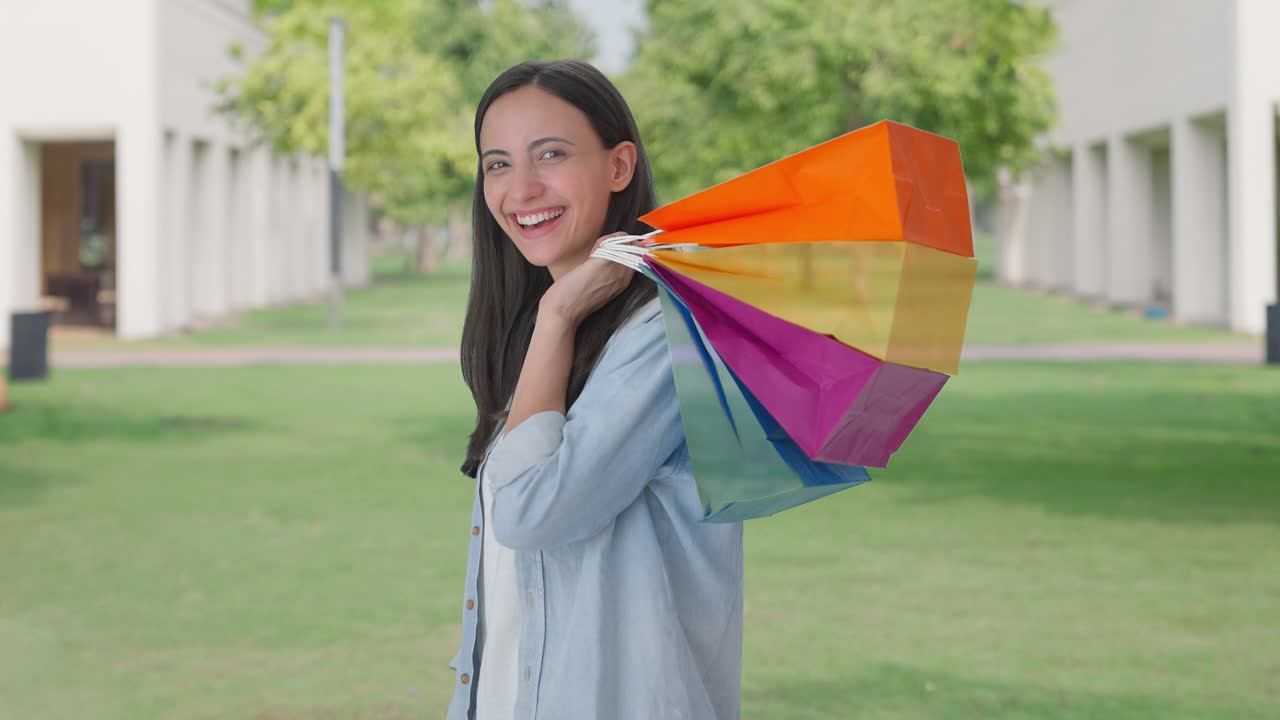 쇼핑 가방 을 들고 포즈 를 취하는 행복 한 인도인 소녀