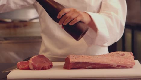 chef sazonando un pedazo de carne de res