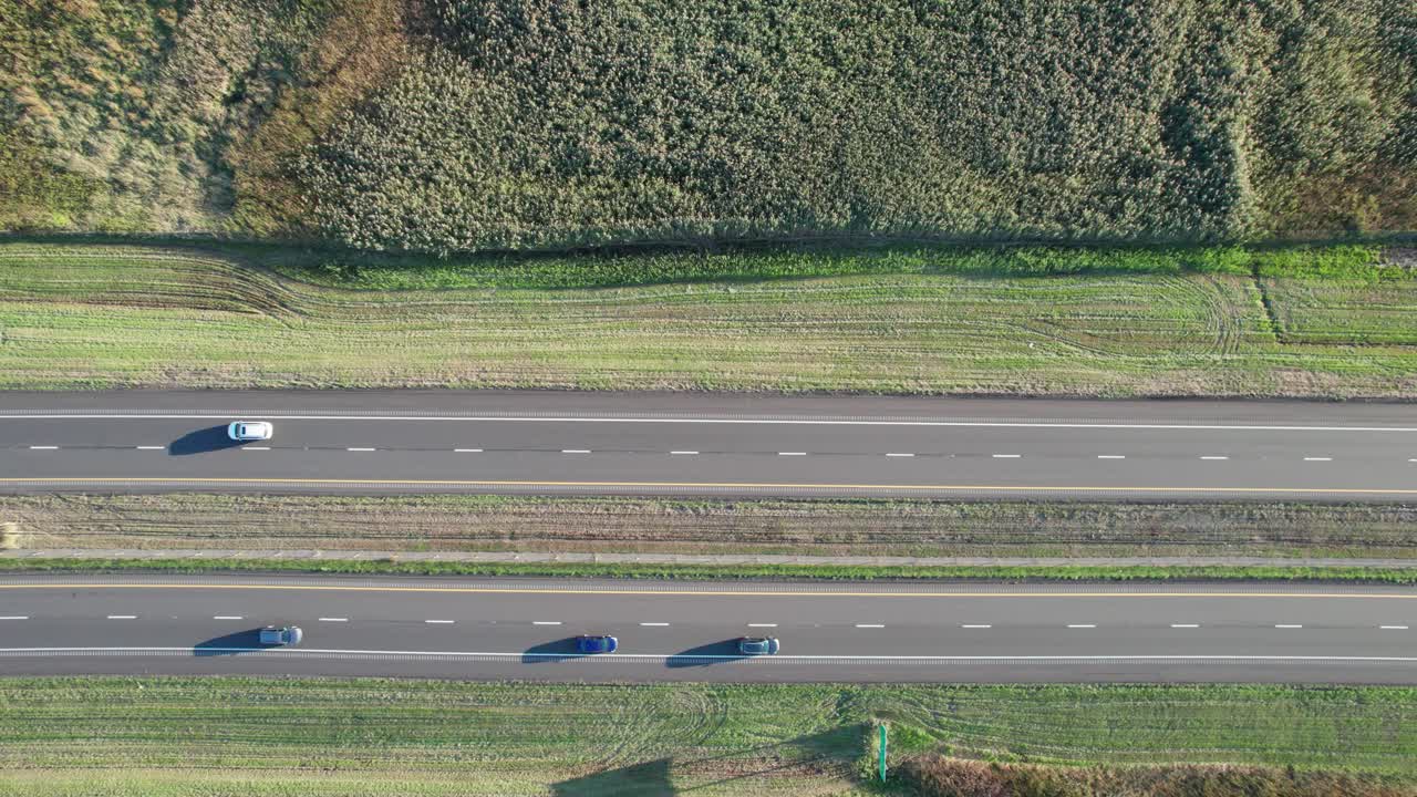 낮에 시골의 녹색 풍경을 통과하는 양방향 고속도로에서 공중 드론 하향식 촬영
