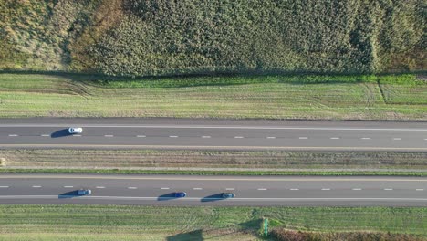 Luftdrohne-Von-Oben-Nach-Unten-über-Eine-Zwei-Wege-Autobahn-Geschossen,-Die-Tagsüber-Durch-Ländliche-Grüne-Landschaft-Führt