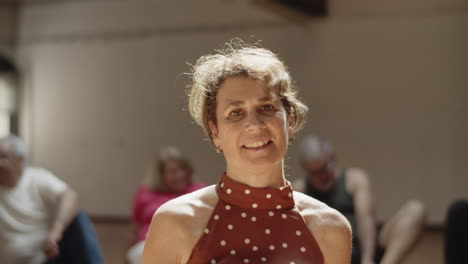 portrait of peaceful senior woman sitting on floor in ballroom