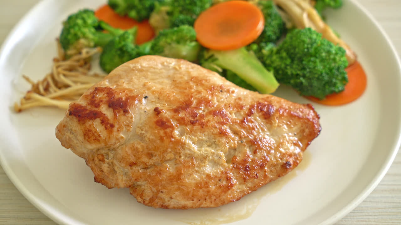 filete de pollo a la parrilla con verduras en un plato blanco