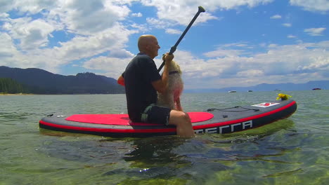 un hombre y un perro remando en el lago tahoe