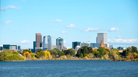 Time-lapse-of-Denver's-downtown-skyscrapers-on-a-sunny-way-with-Sloan-Lake-prominently-featured-in-the-foreground