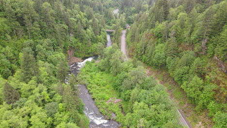 Beautiful-aerial-drone-shot-of-the-Washougal-River-during-day-time,-adjacent-to-a-road-and-surrounded-by-forest