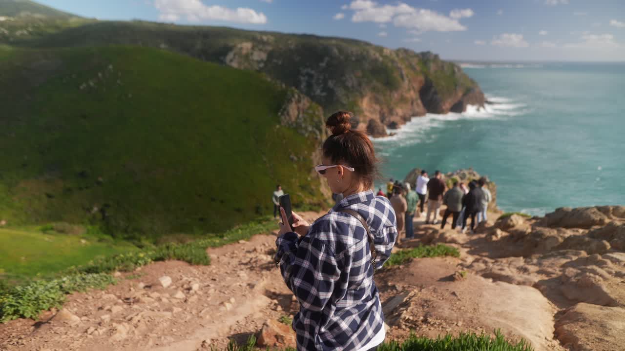 Woman Taking Photo of Coastal Cliff View