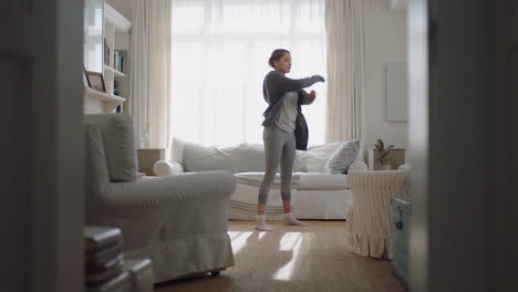 happy-young-woman-dancing-at-home-having-fun-listening-to-music-wearing-headphones-enjoying-weekend-celebration-with-funky-dance-moves