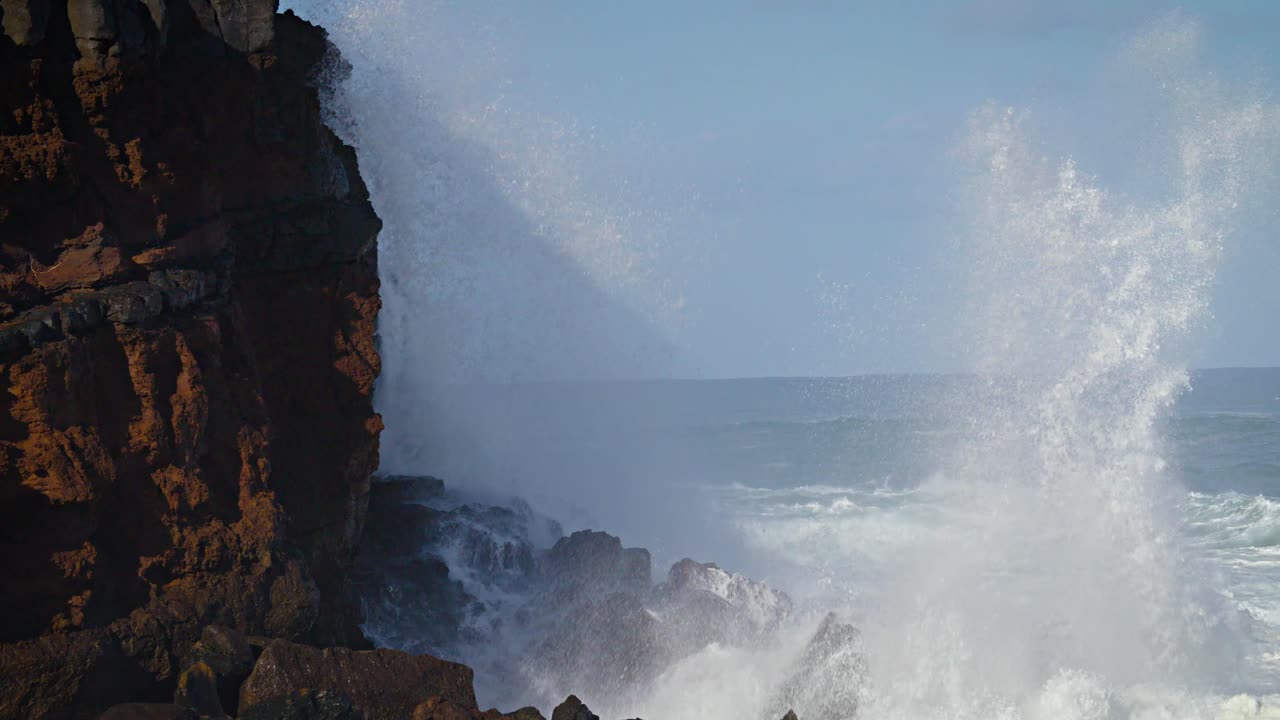 grandes olas ruedan en la costa de hawaii en cámara lenta y rompen a lo largo de una costa escarpada 2