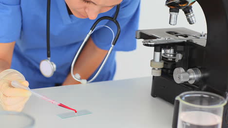 científica preparando una diapositiva para un microscopio