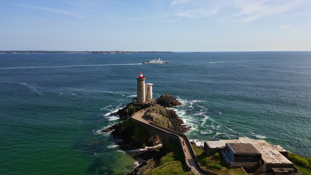 Petit Minou Lighthouse with warship in background, France. Aerial forward, Plouzané, Brittany, France