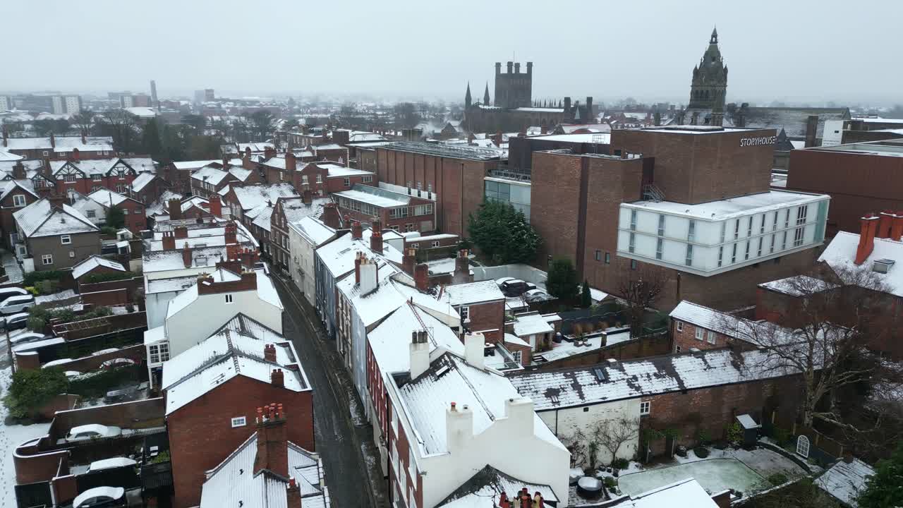 A drone shot of Chester on a gloomy winter day, with snow-covered rooftops and streets under a gray sky.