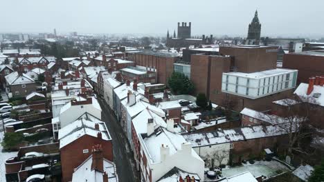 a drone shot of chester on a gloomy winter day, with snow-covered rooftops and streets under a gray sky.