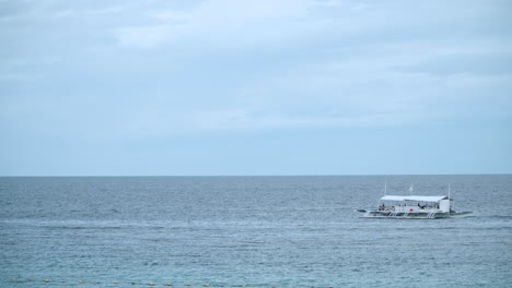 Outrigger-Boat-Patrolling-In-The-Sea-Of-Mactan-Island-In-Cebu,-Philippines-At-Daytime
