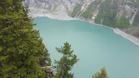 tranquil waters of oeschinen lake nestled between huge alpine mountains: breathtaking 4k aerial view of the swiss alps and alpine flora in the heart of nature