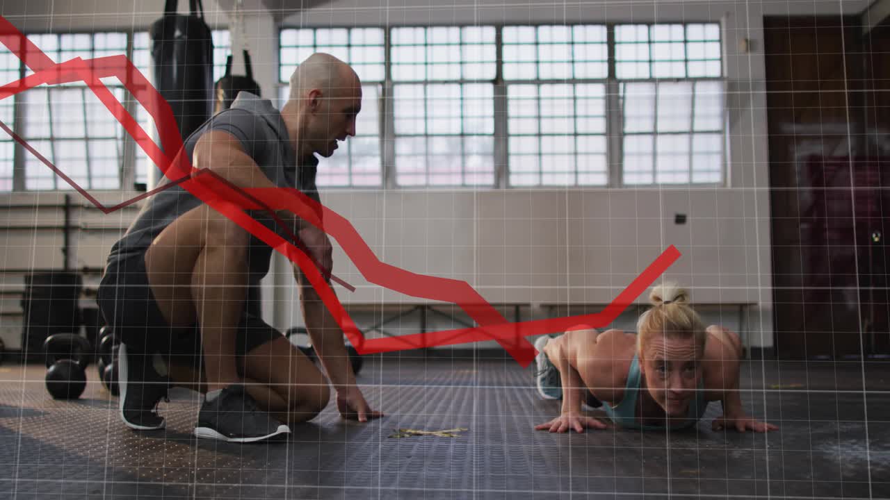 Coach cueing trainee on mat, pushing up while red graph rising over scene tracking reps