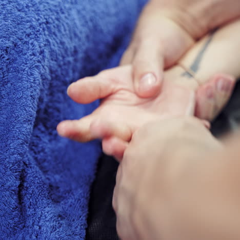 male massagist doing healthcare massage on the female's hand. close-up man's hand massaging woman's fingers. body care concept