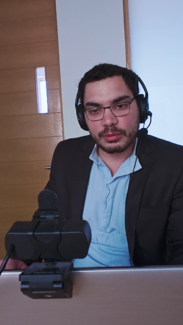 Professional Man with Headset Looking at His Laptop Screen