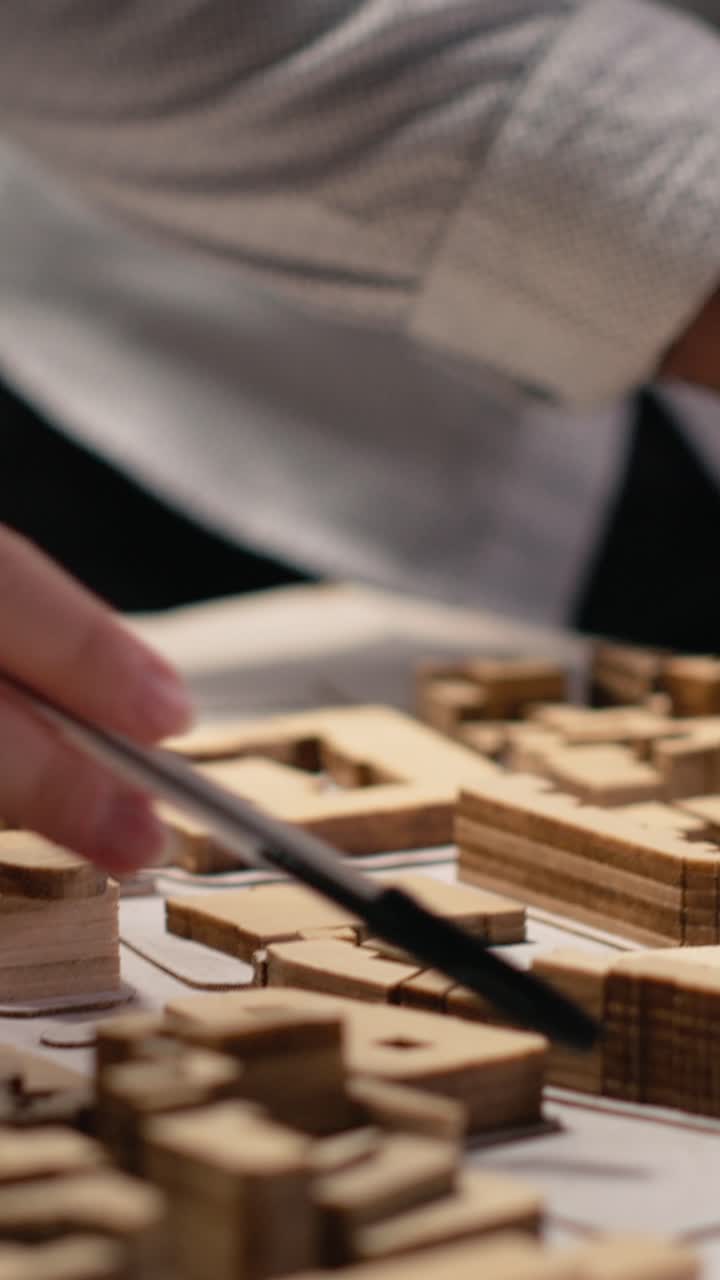 Vertical Video Close up of developers work together on layout city planning initiative