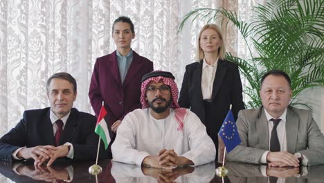 multi-ethnic diplomats and their assistants at negotiation table