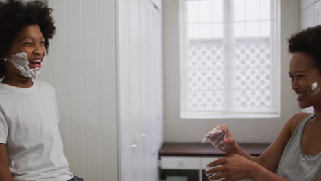 madre e hija de raza mixta divirtiéndose en el baño