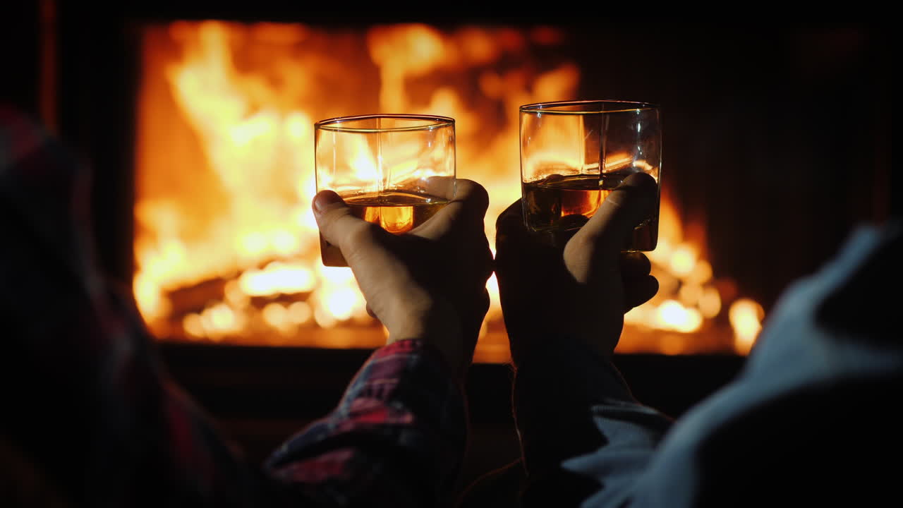 두 남자가 벽난로 옆에서 독한 술을 마시고 있다
