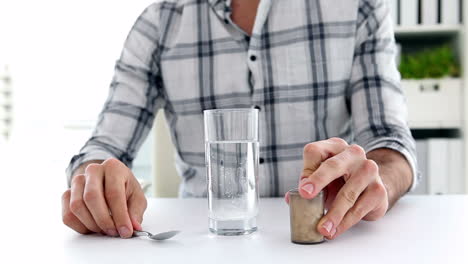 un hombre de negocios preparando un analgésico disoluble.