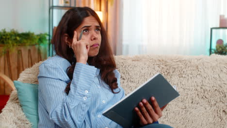 indian woman writing thoughts in diary with gentle smile reflecting with peaceful calm expression