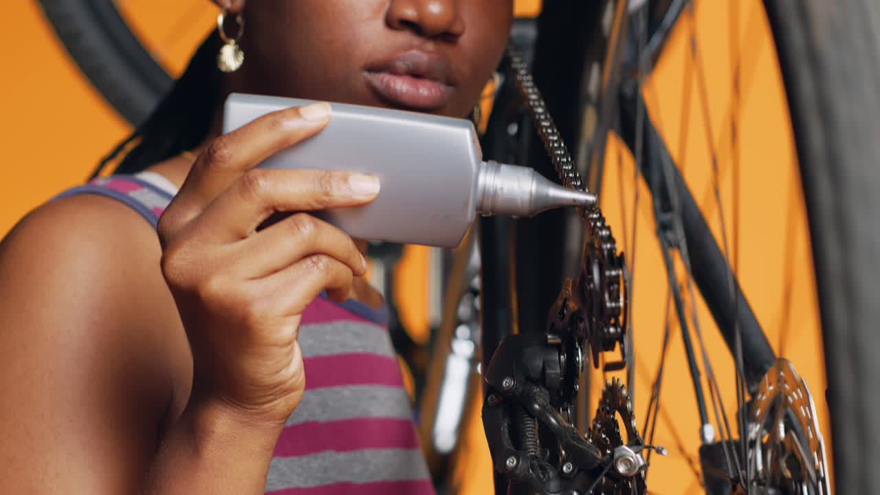 Tecnico che usa un lubrificante specializzato per riparare la catena di bicicletta che scricchiola